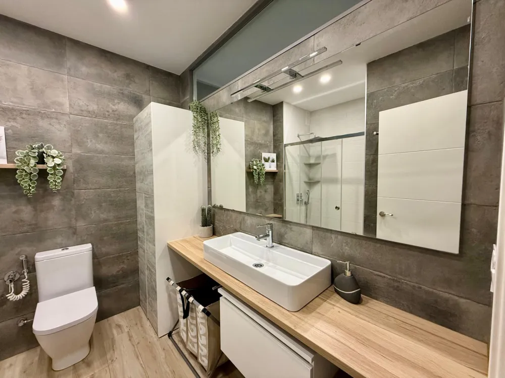 Bathroom renovated by Pamolux with a wooden unit and two washbasins on a worktop