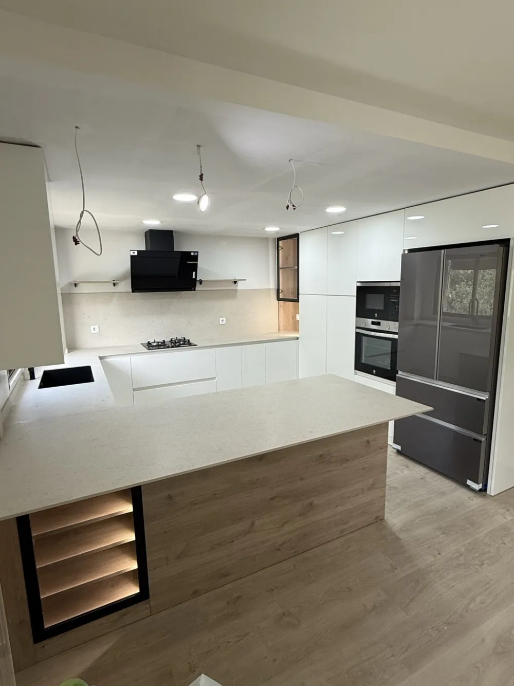 Kitchen renovated by Pamolux: peninsula with worktop, white cabinets and oven column